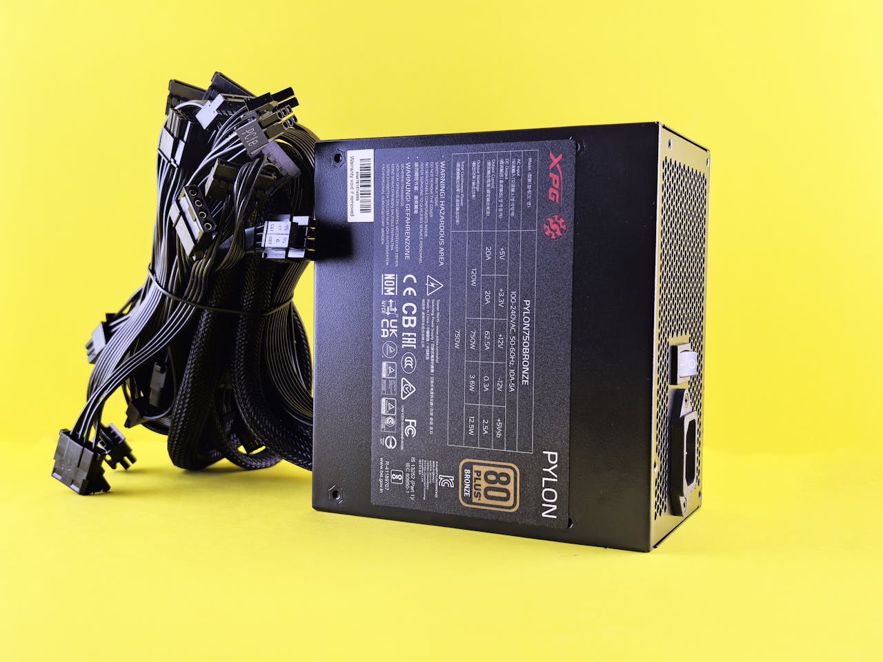Services Black PC power supply unit with cables on a vibrant yellow backdrop. Ideal tech image.
