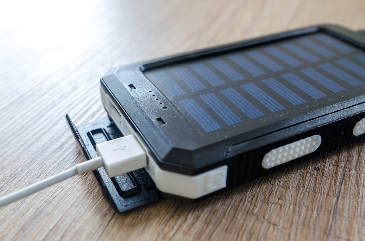 Services A close-up of a solar charger with a USB connection on a wooden surface, showcasing modern technology.